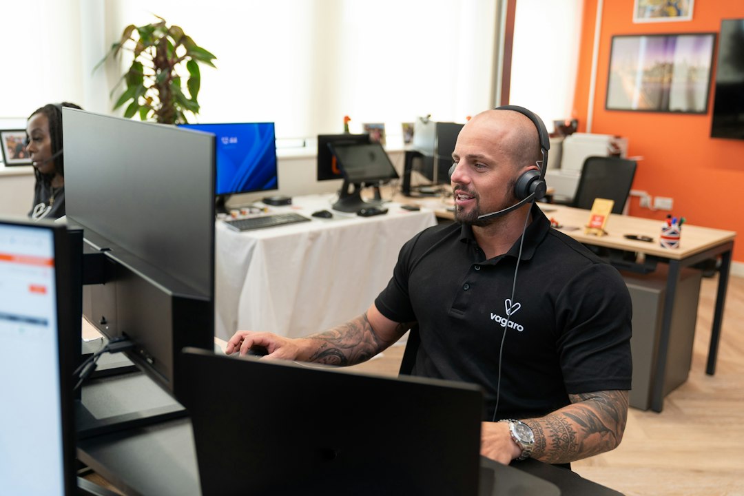 Profesional de atención al cliente utilizando auriculares y ordenador